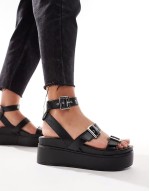 Trombone chunky buckle detail flatforms in black